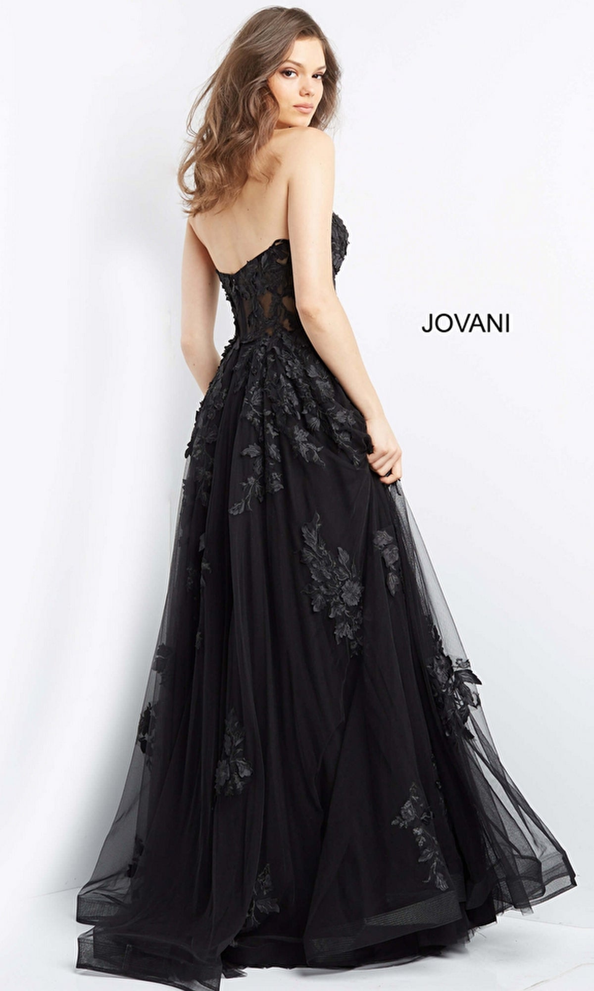 A woman models the Jovani Strapless Long Lace A-Line Prom Dress 07901, featuring floral lace on the bodice and skirt, standing against a plain white background.